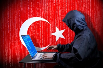 Anonymous hooded hacker, flag of Turkey, binary code - cyber attack concept