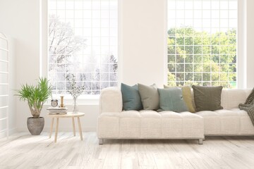 White living room with sofa and winter-summer landscape in window. Scandinavian interior design. 3D illustration