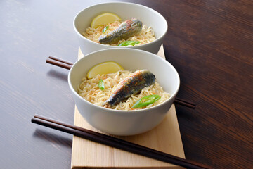Instant noodles with sardine, chillies and seasonings in ceramic bowls. Flat lay top view photo. Food from above.