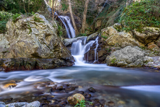 waterfall in the mountains uder the forest in long exposure