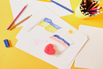 children's drawing, flags of russia and ukraine are drawn on a sheet and a heart made of felt