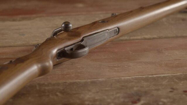 Old WW2 era Mauser Kar98 rifle lying on a wooden surface