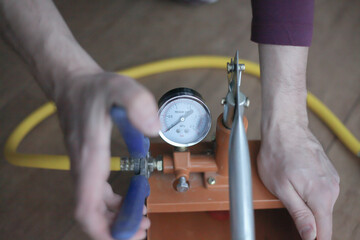 Pressure tester pump is in the hands of a worker