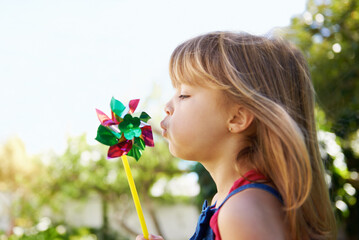 All i need to have fun.... Shot of a cute little girl playing with a pinwheel outside.