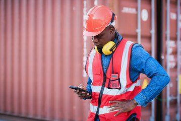 Fototapeta premium African black male worker standing smiling happily and wearing safety work equipment clothes Work at a warehouse, ship, cargo, import, export industry.