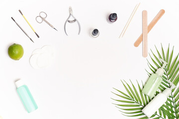 Nail care. Flat lay manicure or pedicure tools on white table with green leaves. High quality photo