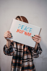 Protesting woman holding a placard with the inscription, Peace no war