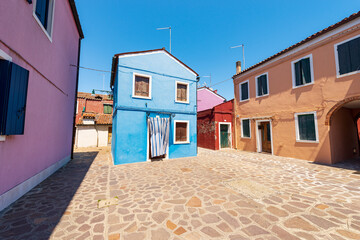 Fototapeta na wymiar Old small beautiful colorful houses with bright colors in Burano island in a sunny spring day. Venetian lagoon, Venice, UNESCO world heritage site, Veneto, Italy, southern Europe.