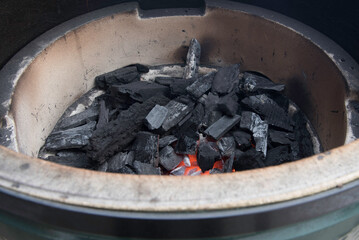 Lit lump charcoal inside a grill.