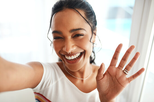 Hi everyone, welcome back to the channel. Cropped portrait of an attractive young blogger standing in her home and waving at the camera during a selfie.