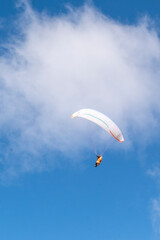 A paraglider pilot in a sky