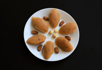 Turkish famous traditional homemade flour halva served with walnut in plate on rustic background, turkish dessert for holy night or funeral