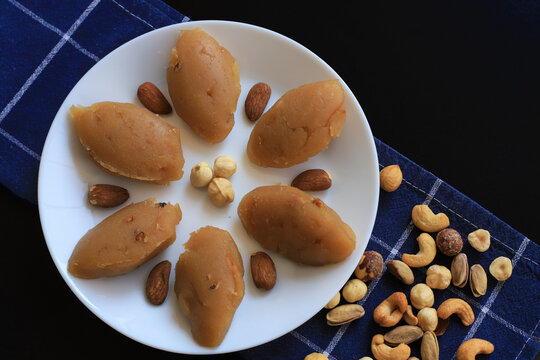Turkish famous traditional homemade flour halva served with walnut in plate on rustic background, turkish dessert for holy night or funeral