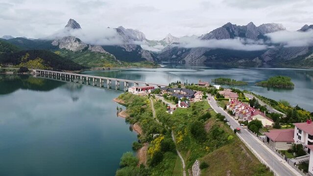 Riano, Castile and Leon, Spain - Aerial Drone View of the Famous Bridge, Cloudy Mountains and Water Mirror at Nature Park Monta&ntilde;a de Ria&ntilde;o and Mampodre