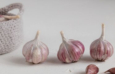 Three organic garlic bulbs close up on a white background.