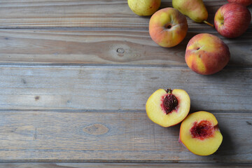Naklejka na ściany i meble fresh peaches, pears and apples on wooden background