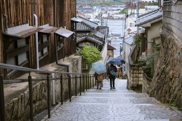 Tourists with umbrella walking downhill in Onomichi City, Hiroshima, Japan　雨の尾道 傘をさして坂道を下る観光客