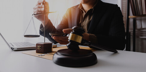 Partial view of lawyers in suits working together on project at workplace with gavel and laptop in office