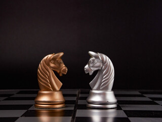 One chess piece stands against a full set of chess pieces. The concept of strategy, planning and decision-making