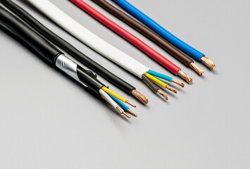 Different types of copper wires with insulation on a gray background