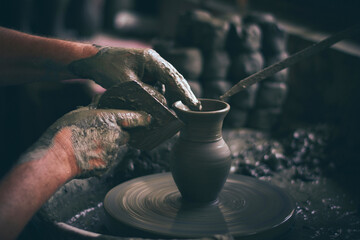 The craftsman makes clay jugs in his workshop