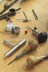 Top view of different goldsmiths engraver tools on the jewelry workplace. Desktop for craft jewelry making with professional tools. Gold jewelry production concept.
