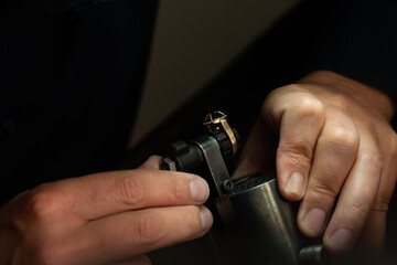 Hands of a jeweler at work. Jeweler fixes the gold ring. Closeup shot