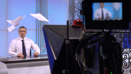 News anchor in the studio, live. A charismatic white man discussing daily events .