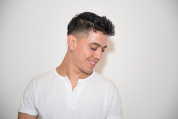 Fototapeta premium nice guy, dark-haired, white test, white t-shirt, looking to the side, with neutral background