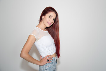 red-haired girl, smiling, looking straight ahead, with neutral background