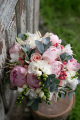 Pink wedding bouquet, composed of roses, freesias, peonies, hypericum, astilba and eucalypthus.