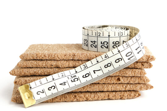 Rye bread and measuring tape on a white background.Popular product is delicious and healthy food for weight loss.