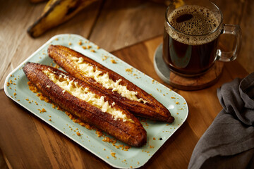 Ecuadorian maduro con queso consists of baked ripe plantains stuffed with cheese. It’s on a...