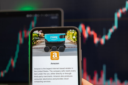 Amazon Stock Price Increasing On The Trading Market With Uptrend Line Graph Bar Chart On The Background. Man Holding A Mobile Phone With Company Logo, February 2022, San Francisco, USA