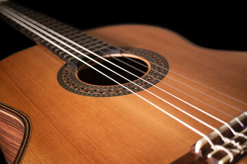 Classical guitar on black background. Acoustic guitar concept.Perfect for flyer, card, poster or wallpaper