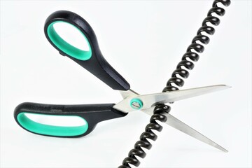 Scissors cutting wire for landline phone communication. It is used inside residential and office premises. The concept of breaking the connection.