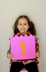 happy little girl holding number