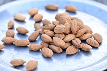 closeup the bunch red brown almond nuts over out of focus grey brown background.