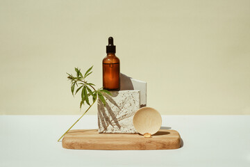 CBD oil in bottle, cannabis bush, hemp on geometric podium