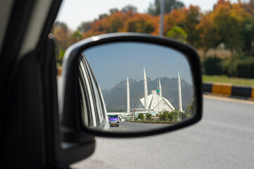 A beautiful view of Faisal Mosque Islamabad in a car mirror