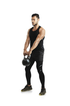 Committed To Staying Fit And Healthy. Studio Shot Of A Fit Young Man Working Out With A Kettle Bell Against A White Background.