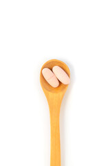 Pills on a spoon isolate on a white background. Selective focus.