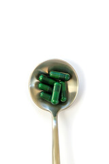 Pills on a spoon isolate on a white background. Selective focus.