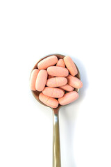 Pills on a spoon isolate on a white background. Selective focus.