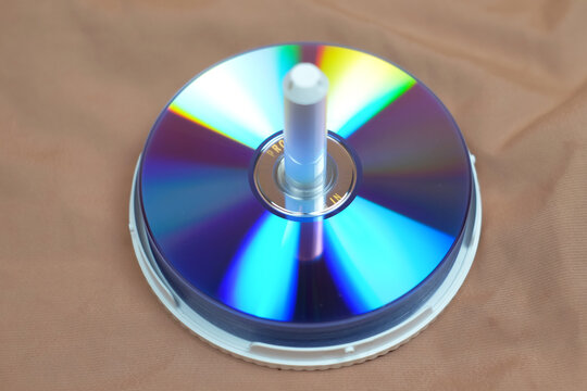 Pile of VCD or DVD discs isolated on brown background