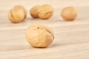 Walnuts on a wooden background, one nut in the foreground