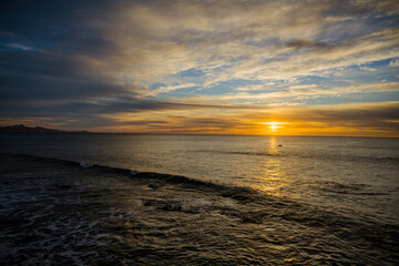 Fototapeta na wymiar Sunrise on the beach with wave wide angle