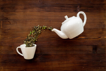 Tea background o white teapot and cup with dry tea leaves
