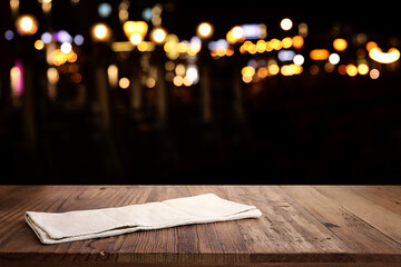 background Image of wooden table in front of abstract blurred restaurant lights