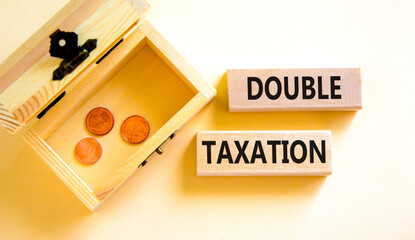 Double taxation symbol. Concept words Double taxation on wooden blocks on a beautiful white table white background. Wooden chest with coins. Business tax and double taxation concept, copy space.